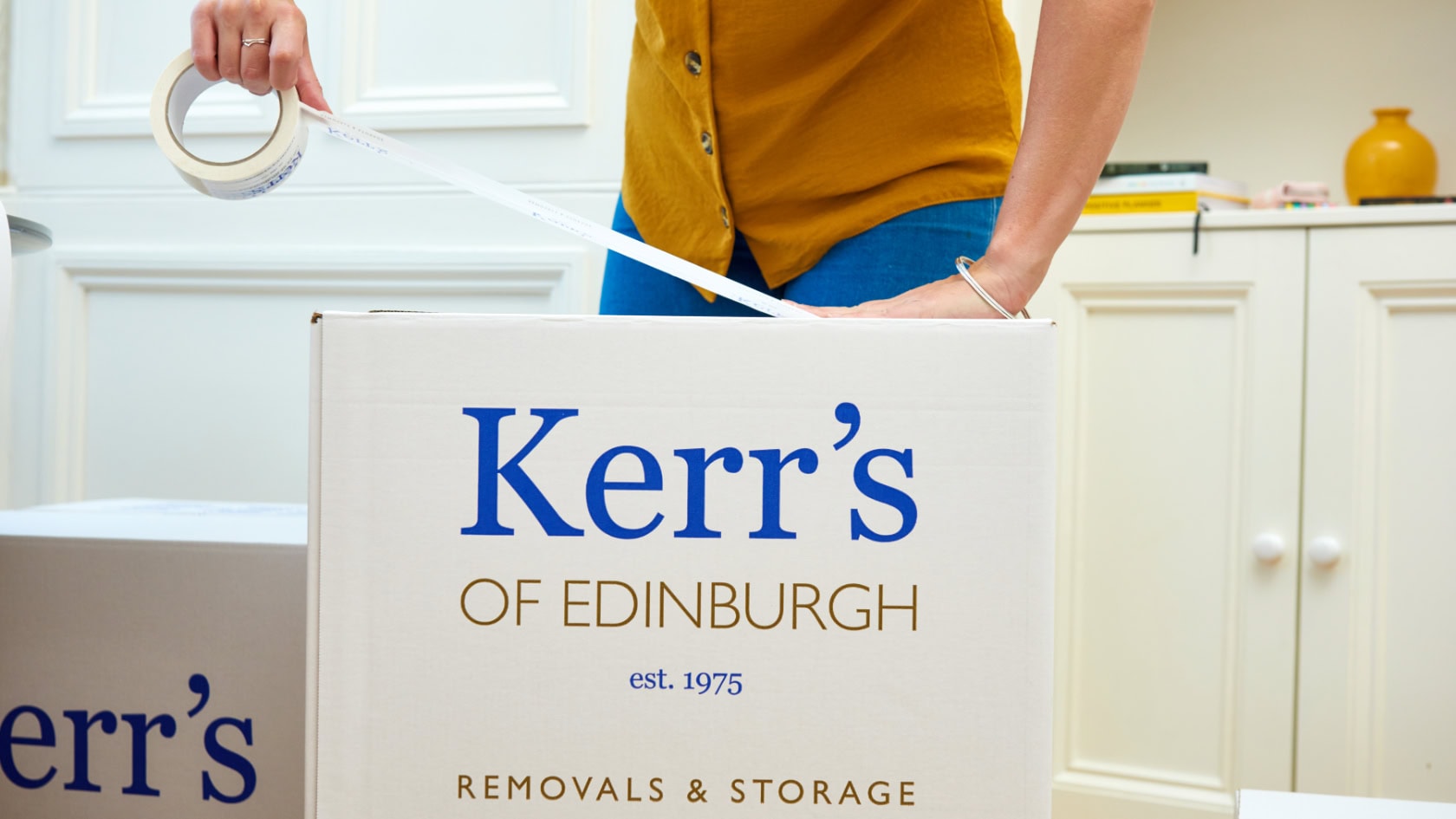 Self storage Edinburgh - woman packing belongings into a Kerr's storage box
