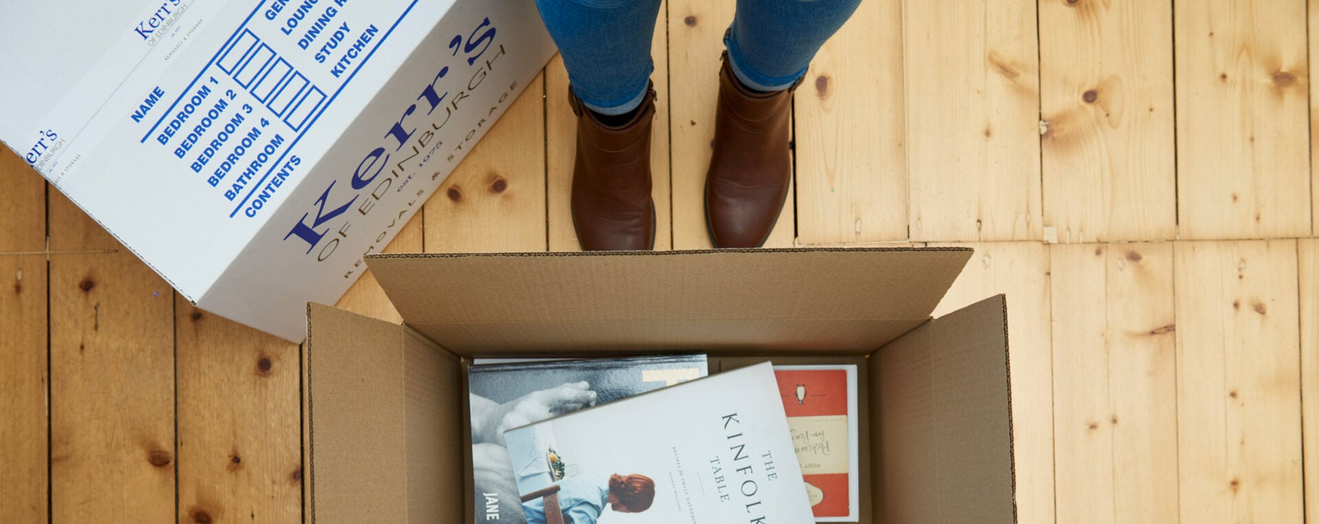 Removals reviews Edinburgh - Kerr's branded box being carefully packed with books
